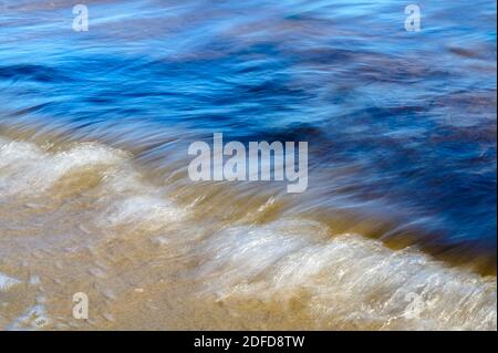 Vagues sur la grève acquise avec une vitesse d'obturation lente. Résumé fond naturel de mouvement. Banque D'Images