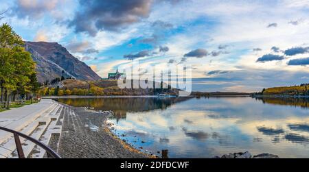 Parc national des Lacs-Waterton bord du lac en automne saison des feuillages matin. Ciel bleu, nuages colorés réfléchissent sur la surface du lac comme un miroir au lever du soleil. Banque D'Images