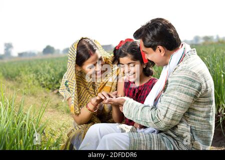 Bonne famille indienne d'agriculteur dans le domaine agricole Banque D'Images