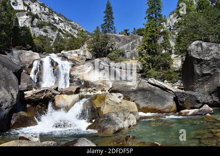 Mist Falls dans Paradise Valley, parc national de Kings Canyon, Californie, États-Unis. L'eau se précipite sur des rochers et des rochers gris lacustres. Pins et ciel bleu. Banque D'Images