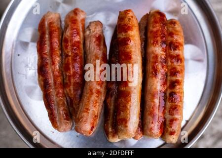 De délicieuses saucisses de viande grillée sont sur un plateau en fer. Oktoberfest. Banque D'Images