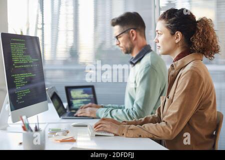 Programmeurs travaillant sur l'ordinateur dans le bureau INFORMATIQUE dactylographiant le codage de données dans le logiciel Banque D'Images
