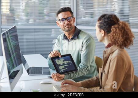 Deux programmeurs professionnels coopérant et travaillant sur le projet de site Web dans un logiciel de développement sur ordinateur de bureau dans la société Banque D'Images