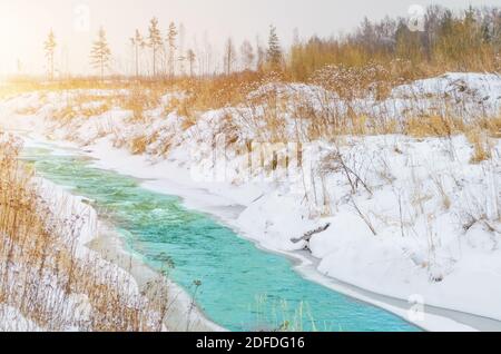 Rivière rugueuse au pied des montagnes dans une forêt turquoise, bleue, verte en hiver, de glace et de neige autour du paysage Banque D'Images