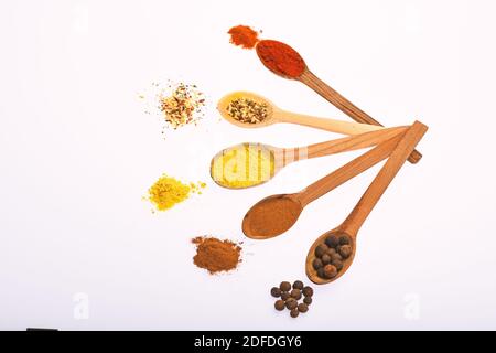 Concept condiments et épices. Cuillères aux épices comme le poivron rouge, le curcuma et la cannelle sur fond blanc. Composition en cuillères avec épices. Cuillères remplies d'herbes et d'épices de cuisine. Banque D'Images