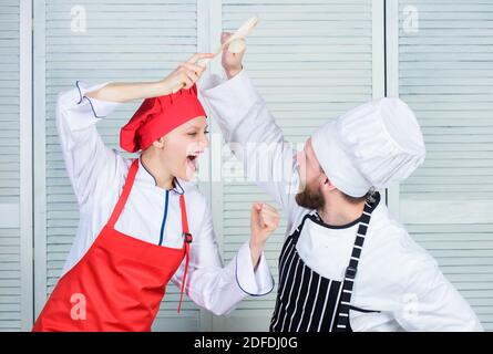 Cuisine ultime défi. Bataille de deux chefs culinaires. Couple en compétition en arts culinaires Cuisine règles. Qui mieux cuisiner. Bataille culinaire concept. Femme et homme barbu show culinaire concurrents. Banque D'Images