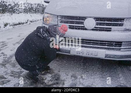 Mamor Tor, Royaume-Uni. 4 décembre 2020. Une femme tente de réparer sa voiture près de Mamor Tor après une chute de neige la nuit dernière. Credit: Ioannis Alexopoulos/Alamy Live News Banque D'Images