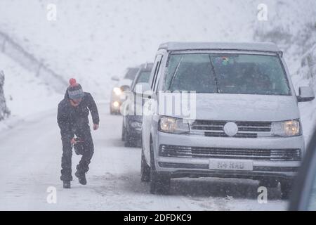 Mamor Tor, Royaume-Uni. 4 décembre 2020. Une femme tente de réparer sa voiture près de Mamor Tor après une chute de neige la nuit dernière. Credit: Ioannis Alexopoulos/Alamy Live News Banque D'Images