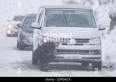 Mamor Tor, Royaume-Uni. 4 décembre 2020. Une femme tente de réparer sa voiture près de Mamor Tor après une chute de neige la nuit dernière. Credit: Ioannis Alexopoulos/Alamy Live News Banque D'Images