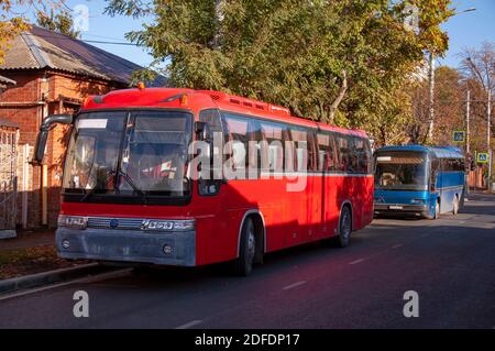 Deux bus passagers rouges et bleus se tenant le long de la route garée Banque D'Images