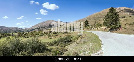 Paysage avec route de montagne se courbant sur les pentes vertes du pic de San Franco, tourné en lumière vive de l'est, l'Aquila, Abruzzo, Italie Banque D'Images