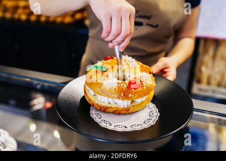 boulanger servant un gâteau frais sur une assiette noire Banque D'Images