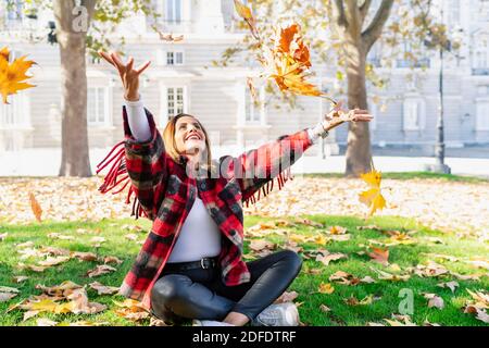 femme jouant dans l'herbe jouant avec les feuilles Banque D'Images