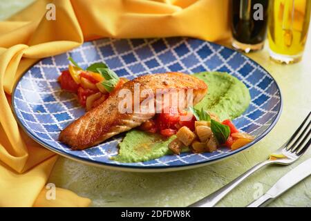 Saumon aux légumes ratatouille et purée de pois verts sur une assiette de table lumineuse. Concept de saine alimentation pour le menu. Banque D'Images