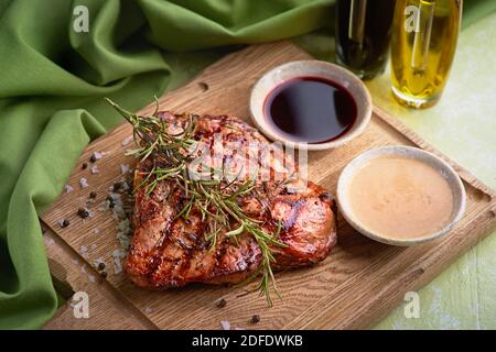 Steak florentin grillé sur une planche à découper. Viande de bœuf cuite. Fond en bois blanc. Concept de saine alimentation pour le menu. Banque D'Images