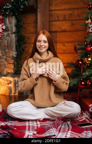 Portrait de la jeune femme aimante tenant doucement dans la main près Carte de Noël coeur à l'aimé Banque D'Images