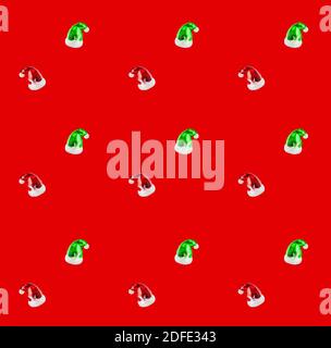 Motif sans couture, jouets de Noël en forme de chapeau de père Noël sur fond rouge Banque D'Images