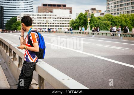 Jeune asiatique sur le pont de Westminster, portant une chemise qui reproduit le drapeau de l'Union Jack, Londres, Angleterre, Royaume-Uni, Europe Banque D'Images