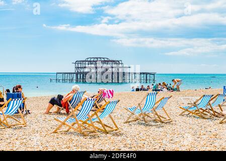 Les gens se détendent à la plage à côté de la jetée ouest de Brighton. Brighton, East Sussex, Angleterre, Royaume-Uni, Europe Banque D'Images