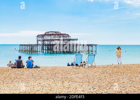 Les gens se détendent à la plage à côté de la jetée ouest de Brighton. Brighton, East Sussex, Angleterre, Royaume-Uni, Europe Banque D'Images