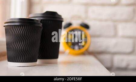 Comptoir de bar à cappuccino, deux verres avec café aromatique, sur le fond d'un mur de briques avec une horloge rétro avec un réveil, gros plan. Banque D'Images