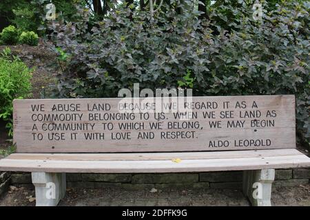 Un banc de bois gravé avec une citation inspirante d'Aldo Leopold dans un parc à Janesville, Wisconsin, Etats-Unis Banque D'Images
