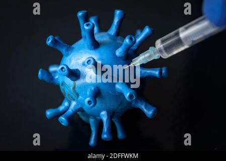 Vaccin et traitement du coronavirus, injection de seringues dans le modèle de la COVID-19 virus corona gros plan. Concept des médicaments du coronavirus, la thérapie, la guérison, la grenaille et Banque D'Images