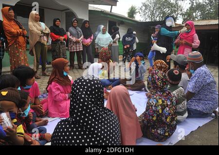 Une femme volontaire vue a donné des points d'esprit pour les enfants qui ont touché par l'éruption du volcan Sinabung pendant a reçu l'aide des volontaires de la Fondation Al Kahfi comme une action d'aide caritative pour les résidents des villages de Kuta Tengah, Berastepu et Gamber (Tiga Serangkai) À la mosquée Al-Jihad à Karo, dans le nord de Sumatra, en Indonésie, le 30 août 2020. Dans plusieurs nouvelles liées à l'éruption du volcan Sinabung, humanely quelques volontaires d'Al-Kahfi sont venus à la psychologie traitée des résidents, en particulier pour les enfants qui vivent sur le seuil d'une zone de danger de catastrophe géologique. Photo par Banque D'Images