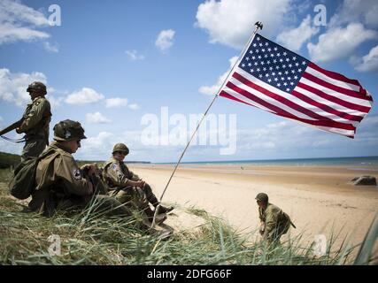 Photo du dossier datée du 03 juin 2019, d'un passionné français de la Seconde Guerre mondiale vêtu d'un soldat américain d'infanterie terrestre de la Seconde Guerre mondiale, marchez le long du rivage d'Omaha Beach, près de Colleville-sur-Mer, en Normandie, en France. Le président Trump a refusé de visiter un cimetière de la première Guerre mondiale en France parce qu'il a déclaré que les soldats américains morts étaient des « perdants » et des « marcheurs ». Les allégations, rapportées pour la première fois dans l'Atlantique, contiennent de multiples cas de M. Trump faisant des remarques désobligeantes sur des membres de l'armée américaine qui ont été capturés ou tués, et qui affirment que le président a refusé d'assister à un service au Cemet américain Aisne-Marne Banque D'Images