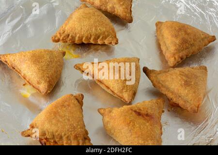 En-cas ou hors-d'œuvre de la samosa cuits au four sur la feuille d'aluminium sur la plaque de cuisson Banque D'Images