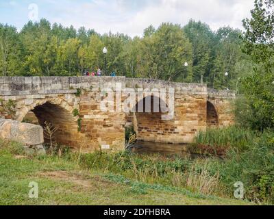 Camino se jette sur le pont chantant (Puente Canto), un pont voûté en pierre du 11trh siècle, au-dessus de la rivière CEA - Sahagun, Castille et Leon, Espagne Banque D'Images