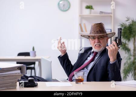 Drôle de vieux patron dans chapeau de cow-boy dans le bureau Banque D'Images