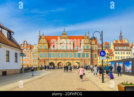 Gdansk, Pologne, 15 avril 2018: Les gens touristes marchant dans la rue piétonne en traversant le pont sur la rivière Motlawa à la porte verte Zielona Brama bâtiment i Banque D'Images