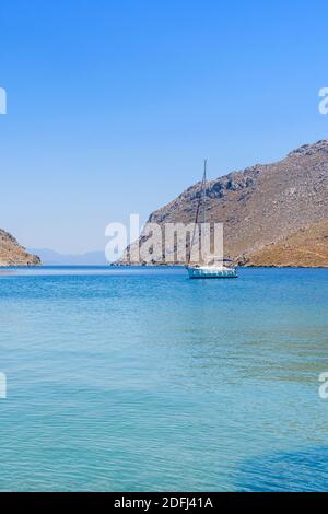 Yacht ancré dans les eaux calmes de Pedi Bay, Symi Island, Dodécanèse, Grèce Banque D'Images