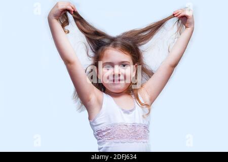 Concept de soins de cheveux avec le portrait de petite fille isolé sur blanc Banque D'Images