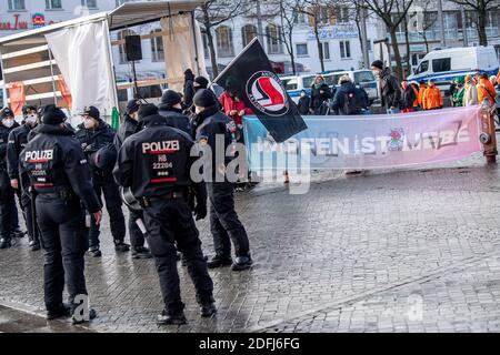 Brême, Allemagne. 05e décembre 2020. Les policiers se tiennent devant une bannière disant « l'inoculation, c'est l'amour ». La police de Brême voulait imposer l'interdiction d'une manifestation de penseur latéral contre la politique de Corona à la gare centrale, qui a également été confirmée par la Cour constitutionnelle fédérale samedi. Dans l'après-midi, la plupart des participants à des contre-manifestations qui n'avaient pas été interdites s'y sont rassemblés. Credit: Sina Schuldt/dpa/Alay Live News Banque D'Images