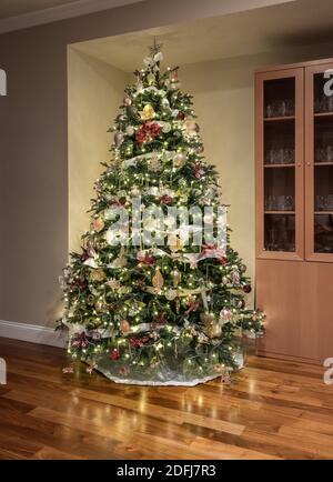 Arbre de Noël soigneusement et joliment décoré dans le coin de une maison moderne avec du parquet Banque D'Images