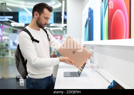Biélorussie ; 05 décembre 2020 ; un jeune homme se tient à une vitrine avec des ordinateurs portables MacBook Air dans la salle d'exposition de la marque Apple Store, pour la cueillette de cadeaux de noël Banque D'Images