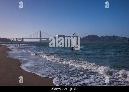 Planche à voile se fermant sur la plage en face du Golden Gate Bridge, un Kite-surfer au loin, San Francisco, Californie, États-Unis d'Amérique Banque D'Images