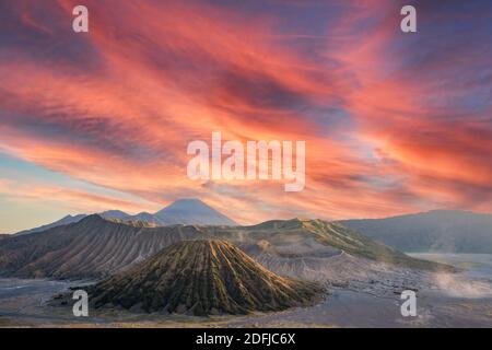 Vue d'en haut, vue aérienne stupéfiante sur le Mont Le bromo et le Mont Batok en premier plan et le Mont Semeru au loin lors d'un coucher de soleil spectaculaire. Banque D'Images