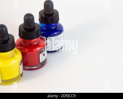 Ensemble de trois pots de peinture acrylique jaune, bleu et rouge. Concept autour de la créativité, de l'art et de la scolarisation. Banque D'Images