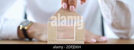 Femme construire la maison à partir de cubes en bois sur la table. Banque D'Images