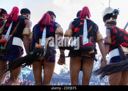 Des hommes tribaux du Nagaland dansant avec leurs armes sur leur De retour au village de Kisama à Nagaland, Inde, le 2 décembre 2016 Banque D'Images