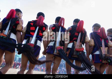 Des hommes tribaux du Nagaland dansant avec leurs armes sur leur De retour au village de Kisama à Nagaland, Inde, le 2 décembre 2016 Banque D'Images