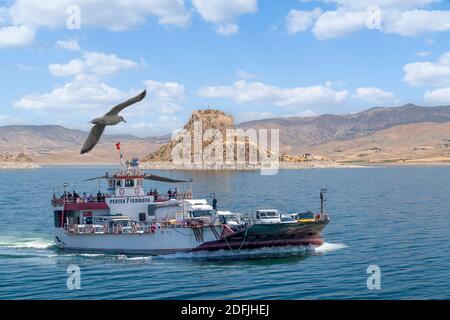 Pertek, Tunceli, Turquie-septembre 18 2020 : le ferry qui relie les villes d'Elazig et de Tunceli et la forteresse de Pertek en arrière-plan Banque D'Images