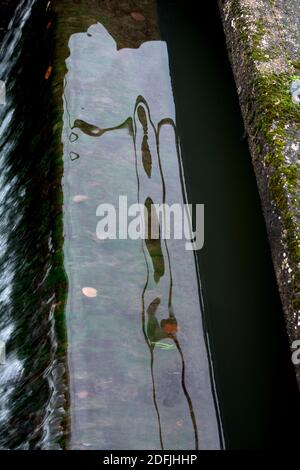 Réflexions abstraites dans un débordement d'écluse à Hatton Locks, Grand Union Canal, Warwickshire, Royaume-Uni Banque D'Images