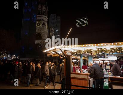 Berlin, Allemagne. 05e décembre 2020. Les gens se tiennent dans un stand de Noël en face du Kaiser-Wilhelms-Gedächtniskirche sur Breitscheidplatz. Dans le quartier berlinois de Charlottenburg-Wilmersdorf, 25 cabines de Noël ont été établies en remplacement des marchés de Noël annulés. Credit: Fabian Sommer/dpa/Alay Live News Banque D'Images