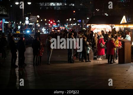 Berlin, Allemagne. 05e décembre 2020. Le samedi du deuxième week-end de l'Avent, les visiteurs se tiennent dans une file d'attente devant un stand de Noël à Breitscheidplatz. Dans le quartier berlinois de Charlottenburg-Wilmersdorf, 25 cabines de Noël ont été établies en remplacement des marchés de Noël annulés. Credit: Fabian Sommer/dpa/Alay Live News Banque D'Images