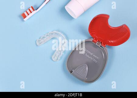 Dents transparentes personnalisées protège-dents aligneurs transparents pour mâchoire inférieure avec étui de rangement, brosse à dents et pâte sur fond bleu Banque D'Images