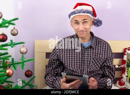Félicitations. en ligne Vœux en ligne de Noël. Homme heureux regardant la caméra, tenant une tablette. Banque D'Images